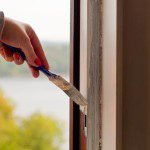 Woman painting a window frame