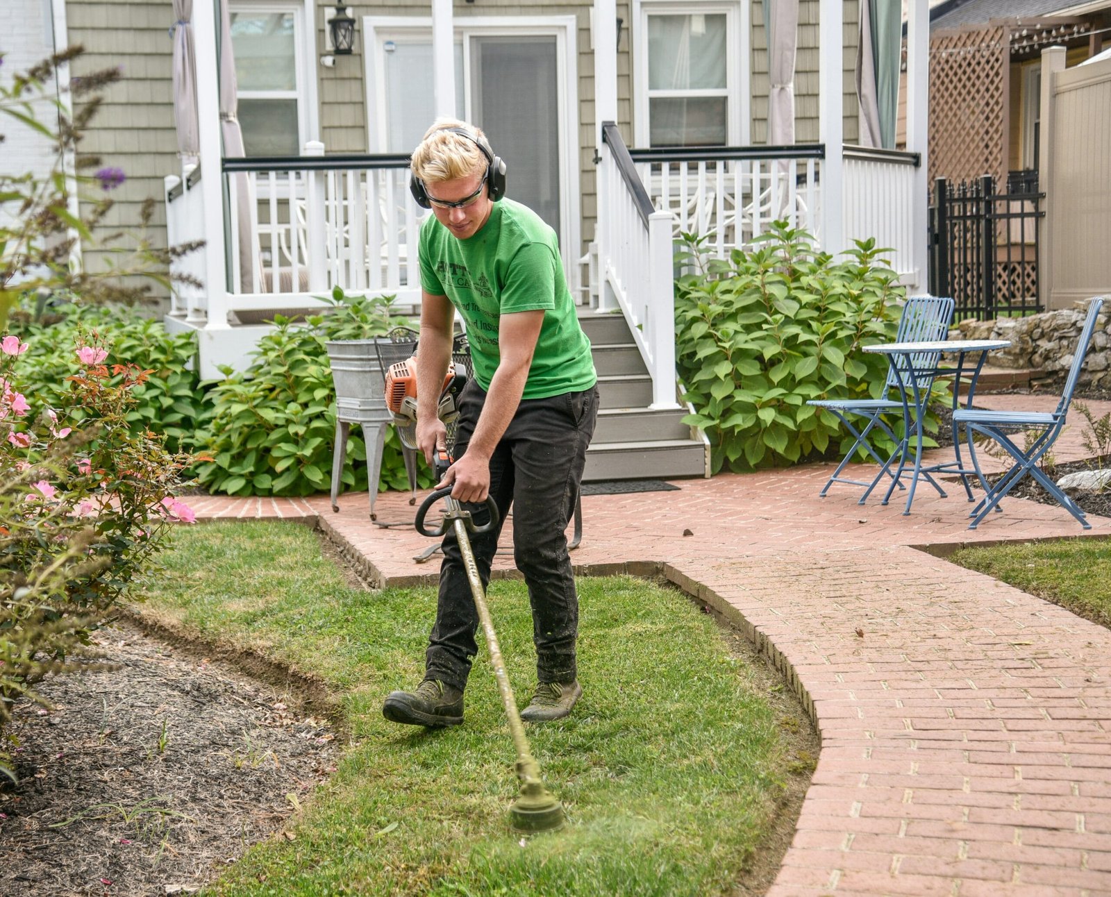 man in green t-shirt and black pants holding black and brown shovel